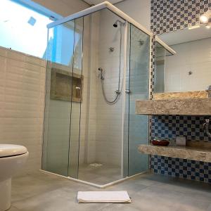 坎波斯杜若尔当Pousada Alpes Azul的浴室里设有玻璃门淋浴