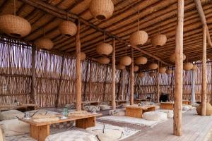 El KariaAlkamar Camp Agafay的大房间设有木桌和天花板上的篮子