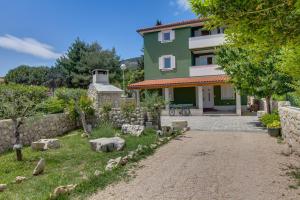 内里吉恩Apartments and rooms by the sea Nerezine, Losinj - 11815的前面有花园的房子