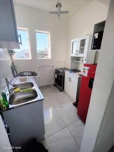 阿里卡La mejor ubicación de Arica的厨房配有水槽和红色冰箱