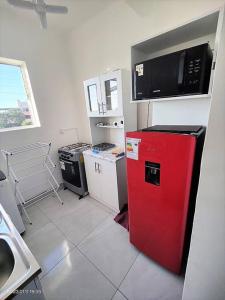 阿里卡La mejor ubicación de Arica的厨房配有红色冰箱和微波炉