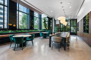 墨尔本Paragon Apartments by CLLIX的用餐室设有桌椅和窗户。
