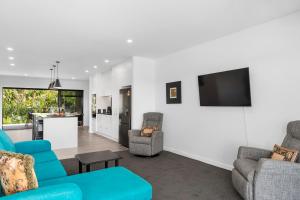 陶波Blue Dun Views - Taupo的客厅配有2把蓝色椅子和电视
