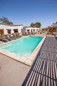 圣佩德罗·德·阿塔卡马拉科切拉酒店 的一个带椅子的大型游泳池