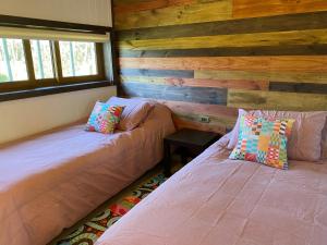 科伊艾科Cabaña Pampa Pinuer Coyhaique的木墙客房的两张床