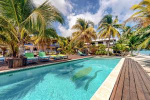 珀拉什奇亚Condo #31 @ Beachside Villas的棕榈树游泳池及度假村