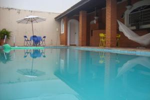 巴乌鲁Black Hotel的房屋旁的游泳池配有椅子和遮阳伞