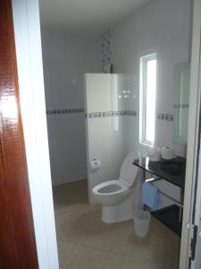 素辇府吉布公寓的白色的浴室设有卫生间和窗户。