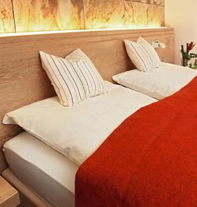 希尔兴巴赫霍夫31酒店的一张红色和白色的床,配有两个枕头