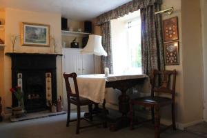 谢普顿马利特Enniskerry - The Loves Cottage的一间带桌椅和窗户的用餐室