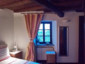 蒙巴鲁佐Altes Backhaus in Maranzana的一间卧室设有一张床和一个窗口