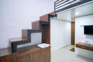 LampungRedDoorz at Jalan Basuki Rahmat Lampung的一间带楼梯和电视的客厅