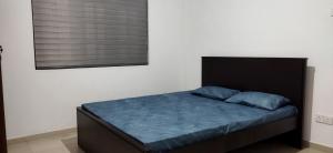AthurugiriyaPeaceful Holiday Home的一间卧室配有一张带蓝色床单的床和一扇窗户。