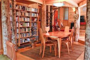 圣何塞德迈波Casa La Montaña的一间带木桌和书架的用餐室