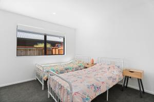 瓦纳卡Northlake Hideaway - Wanaka Holiday Home的一间卧室设有两张床和窗户。