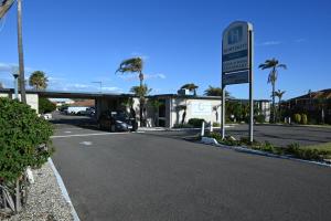 杰拉尔顿Hospitality Geraldton SureStay Collection by Best Western的停在加油站的汽车,有标志