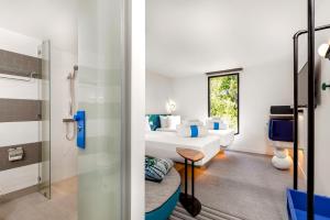 查汶COSI Samui Chaweng Beach - SHA Plus的客房设有一张床和一间带淋浴的浴室。