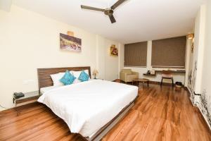 迈索尔SAFARI QUEST的卧室配有一张白色的大床,铺有木地板