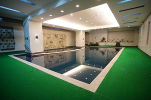 马尼拉Millenia Suites Cozy Studio Unit 3003的一座建筑物内一个绿地游泳池