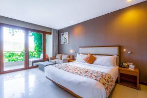 努沙杜瓦VOUK Hotel and Suites Nusa Dua Bali的一间卧室设有一张大床和一个大窗户