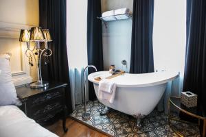 伊登Hotel Australasia的一间带浴缸的浴室,位于一间设有床铺的客房