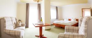 巴特利本韦达Landhotel Biberburg的酒店客房带一张床、一张桌子和椅子