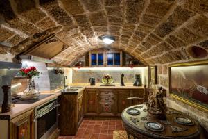 罗德镇Mythic Spa Villa的厨房设有石质天花板和桌子。