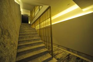 安卡拉The Alpfine Hotel的楼梯,位于一栋铺有木地板并带栏杆的建筑内