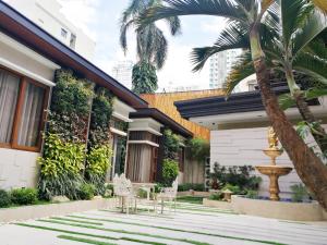 马尼拉Adria Residences - Ruby Garden - 2 Bedroom for 4 person的房屋设有带椅子和喷泉的庭院