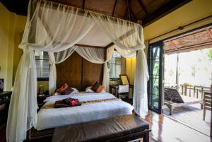 象岛温泉象岛度假村 的一间卧室配有一张带天蓬的大床