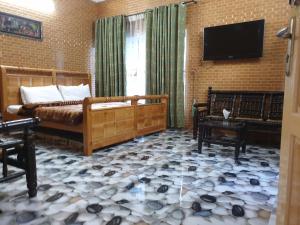 穆扎法拉巴德Kashmir lodge的客厅配有床和平面电视