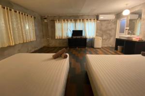 沙美岛月牙湾度假酒店的一间带两张床的卧室和一间带水槽的浴室
