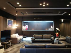 平冢市HOTEL LiVEMAX BUDGET Hiratsuka Ekimae的带沙发和大屏幕的客厅