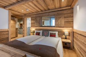 策尔内茨策尔内茨克劳斯酒店的一间带一张大床的卧室,位于带木墙的房间