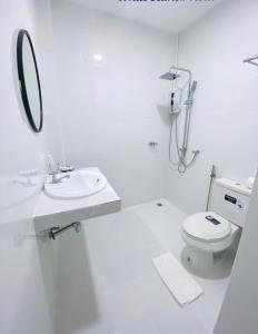 功孟海滩White Seaview Residence的白色的浴室设有水槽和卫生间。