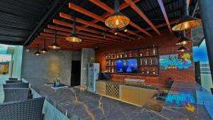 长滩岛长滩岛阿罗哈酒店的厨房设有酒吧,砖墙上配有电视