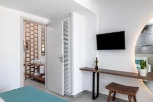 法里拉基Kellys Luxury Apartments的客厅配有书桌和墙上的电视