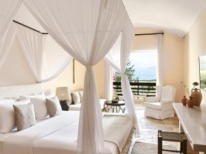 达西亚达西亚LUXME达费尼拉巴伊格雷科泰尔酒店的一间卧室配有一张带天蓬的白色床