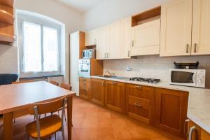 热那亚Waterfront House的厨房配有木制橱柜、桌子和微波炉