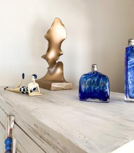 波多河丽La Pausa的上面有雕像的架子,上面有蓝色和金色花瓶