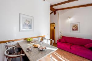 因佩里亚Agriturismo Le Mimose的客厅配有桌子和红色沙发