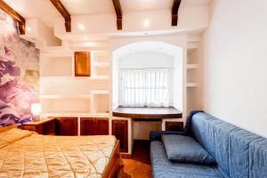 因佩里亚Agriturismo Le Mimose的一间卧室配有一张床、一张沙发和一个窗口