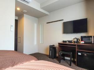 东京HOTEL LiVEMAX Akasaka GRANDE的酒店客房配有一张床和一张书桌及一台电视