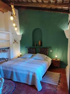 SobrestanyMas Del Llop Blanc - Dog friendly Hostal Rural - B&B的一间卧室,在绿色的墙上配有一张大床