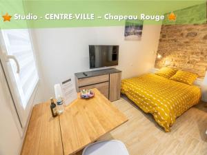 坎佩尔LES NIDS DE SAINT MARC - centre-ville的客房设有一张床和一张桌子及一台电视