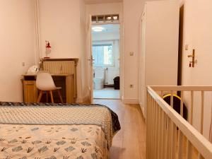 卢森堡Nice rooms in Beggen house - In Luxembourg city的一间卧室配有一张床、一张书桌和一个楼梯