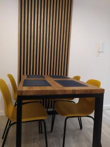 格但斯克Apartament FOCUS DUO的餐桌周围摆放着黄色椅子