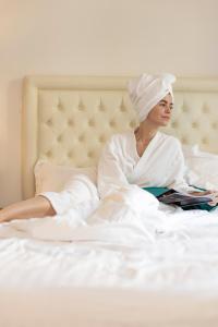 尼斯Hôtel Nice Azur Riviera的躺在床上读书的女人