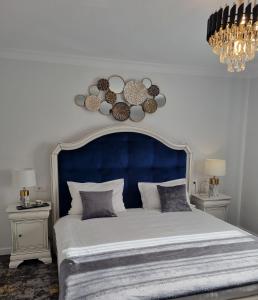 特尔古尼亚姆茨Tesa Boutique Hotel的一张带蓝色床头板的大床和两张桌子
