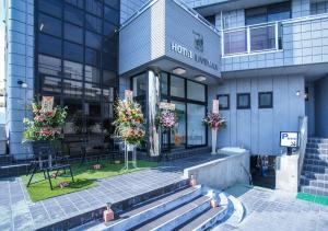 沼田HOTEL LiVEMAX BUDGET Gunma Numata的一座建筑前面有花卉市场